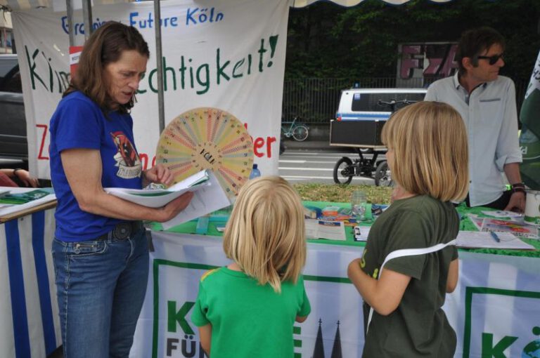 NRW-Tag in Köln - Detailbild vom Stand der Parents for Future Köln - zwei Kinder spielen beim Klimaglücksrad und beantworten Fragen rund um Klima und Nachhaltigkeit