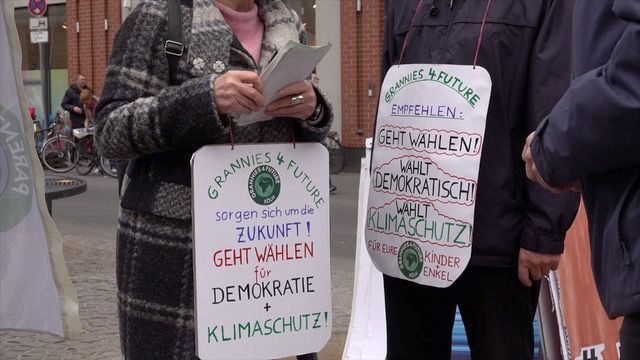 "Wählt Klimaschutz" - Infostand und Kundgebung am 22.02.25 auf dem Chlodwigplatz in Köln Detailansicht von zwi Grannies for Future mit umhängenden Schildern. Links mit der Aufschrift: Grannies for Future sorgen sich um die Zukunft! Geht wählen für Demokratie und Klimaschutz Rechts: Grannies for Future empfehlen: Geht wählen für Demokratie und Klimaschutz. Geht wählen, Wählt demokratisch, wählt Klimaschutz. Für Eure Kinder und Enkel Foto: Ulla Kellerwessel