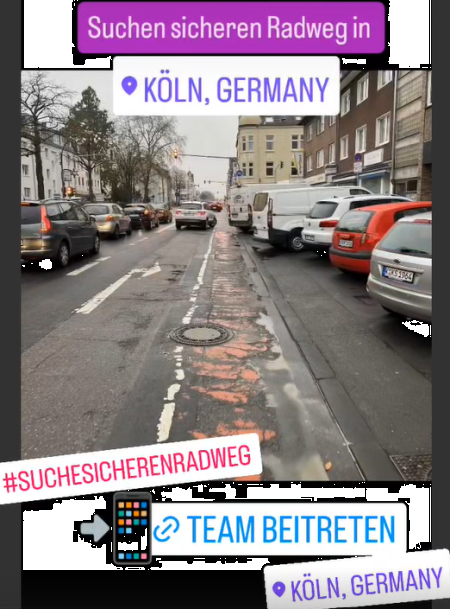 Das Bild zeigt eine Straße in Köln. Zentral ist ein kaputter Radweg zu sehen. Auf der rechten Seite parken PKW und Lieferwagen, deren Heck z.T. in den Radweg hinanragt. Auf der linken Seite sind zwei Spuren für PKW zu sehen. Text: Suche sicheren Radweg in Köln, Germany #SucheSicherenRadweg Team Beitreten beim Stadtradeln 2025